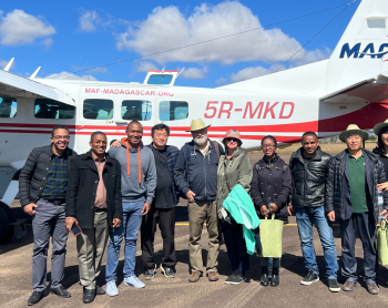 FJKM Bible translation team in front of MAF plane on airstrip in Fianarantsoa