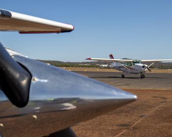 A small aeroplane runs up its engine framed by a prop spinner