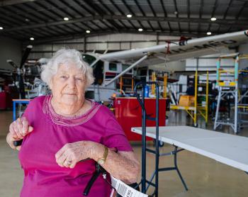Elderly lady in aircraft hangar