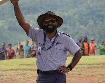 Joseph Tua at Sengapi airstrip posing under the wing