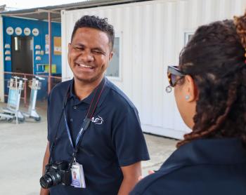 A man smiling next to another person
