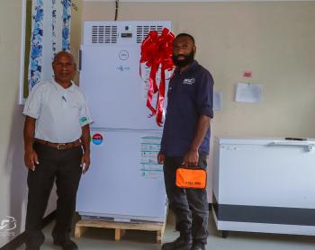 MAF Technologies technician Steven Zato guiding a health worker on the safe use of a solar-powered vaccine fridge.