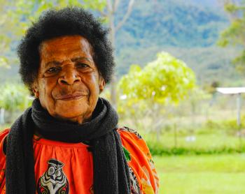 a woman poses for a portrait shot in front of mountain backdrop