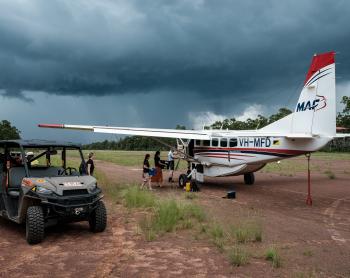 MAF aircraft and offroad buggy on red gravel airstrip