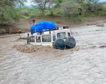 Car in flooded Sanjan river needed to be pulled out with ropes and another veichle on dry land after being bogged in the muddy, flooded rivercrossing 