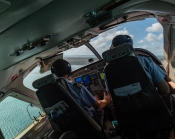 Two pilots in the cockpit of a banking aircraft