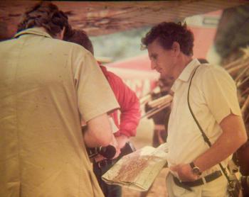 A man looks at a map standing near a plane