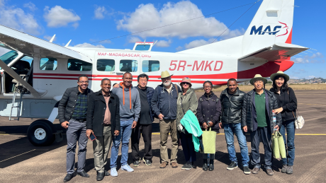 FJKM Bible translation team in front of MAF plane on airstrip in Fianarantsoa