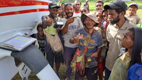 MAF PNG Caravan P2-MAL at Munbil, where people are buying resources from the Bible Box and showing their thumbs up as an acknowledgment that this ministry is available again.
