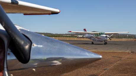 A small aeroplane runs up its engine framed by a prop spinner