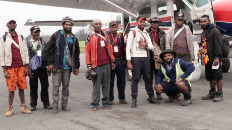 Passengers standing beside a plane