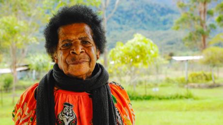a woman poses for a portrait shot in front of mountain backdrop