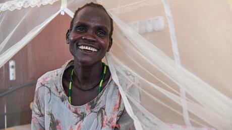 Nyanut is seen smiling in the hospital bed at the Reconciliation Hospital run by ELCAMSS