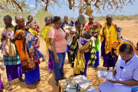 Mothers gather around waiting for the nurse to tend for their children