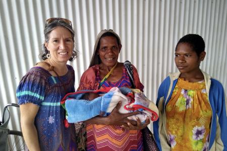 Michelle Venter with 2 Goroka ladies from Mama Care Ministry, holding a newborn baby.