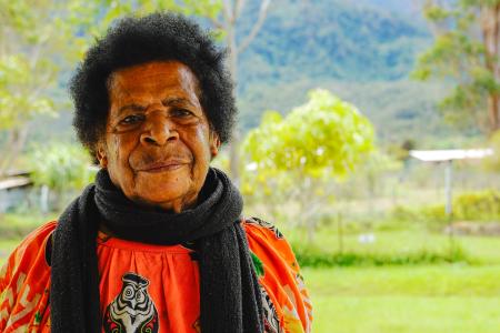 a woman poses for a portrait shot in front of mountain backdrop