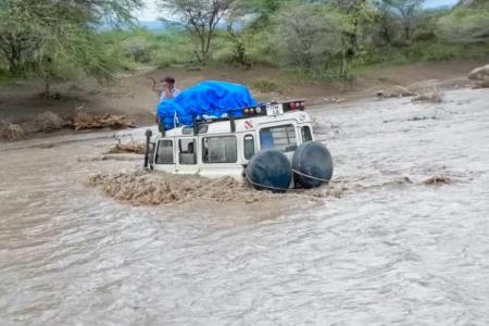 Car in flooded Sanjan river needed to be pulled out with ropes and another veichle on dry land after being bogged in the muddy, flooded rivercrossing 