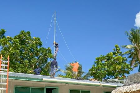 MAF Technologies technicians install HF radio, solar panels, and an inverter at Han Clinic, Carteret Islands