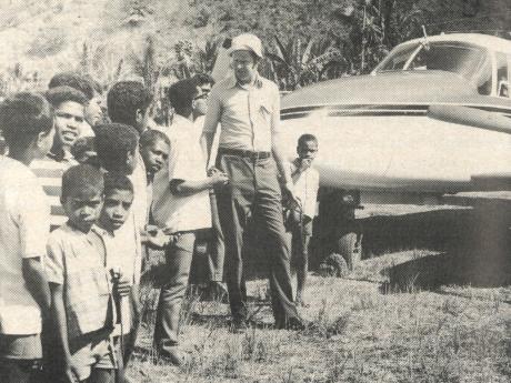 A pilot talks to passengers at a remote airstrip