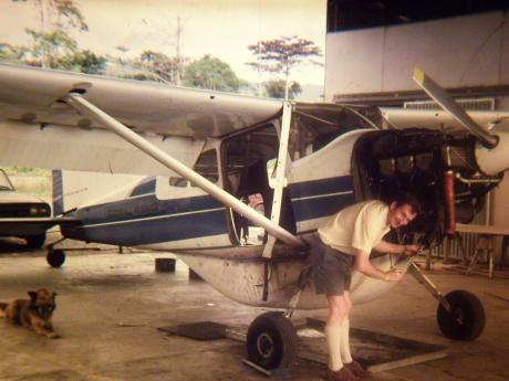 A man works on the engine of a small plane in a hangar