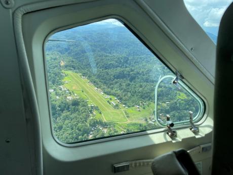 looking out the pilot's window as the plane flies over the Lumi airstrip