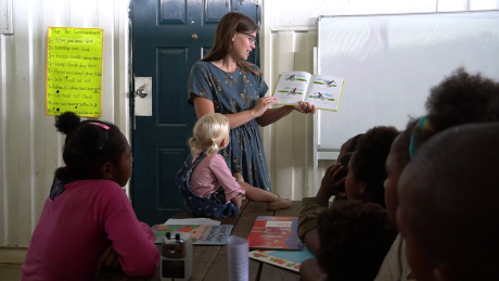 Nellicia Van Saane is teaching the children by reading a story