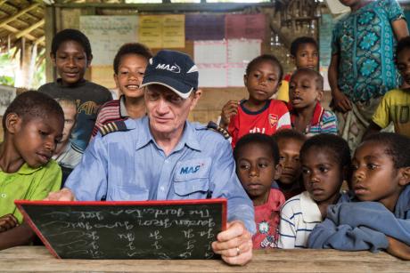 Paul plays with children in the small schoolroom