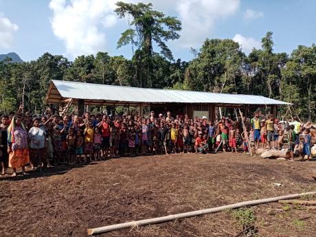 The construction team and community in front of the newly completed school room building at Iteri