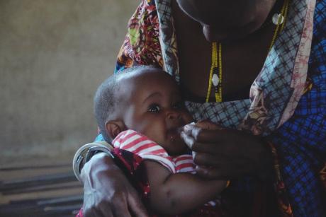 A mother giving her child a vaccine during the clinic in the presence of a nurse