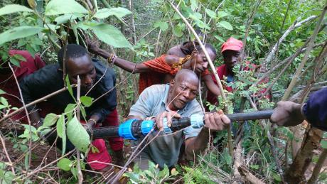 Maasai men working together to connect water pipes that will supply clean water to the community.