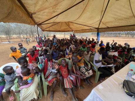 Locals gather around a tent to share the gospel of Christ.