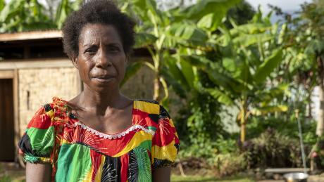 portrait shot of Doris with a PNG hut and greenery as a backdrop