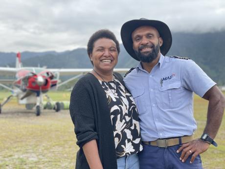 portrait shot of Mrs Kelly-Ann Wampai-Tua and pilot Mr Joseph Tua at remote Telefomin with a MAF aircraft in the backdrop