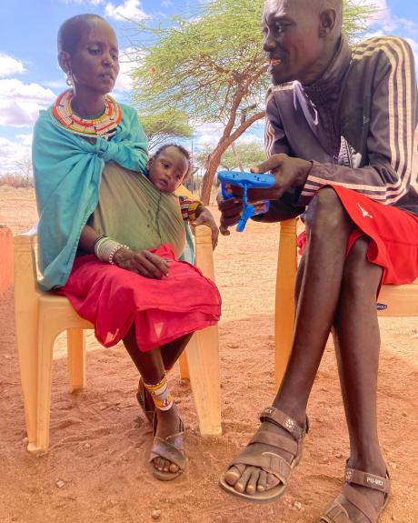 Pastor Francis sharing the gospel of Christ with a woman in Sesia.