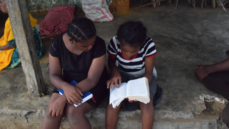 Two locals reading the Bible during a teaching session