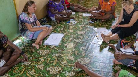 Women sitting in a circle discussing (no faces shown)