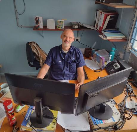 Fraser Norbury sitting at his desk at the MAF HQ in Mount Hagen