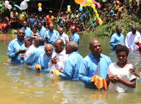 Participants of the Planim Pos are in getting ready to be baptised in the river.