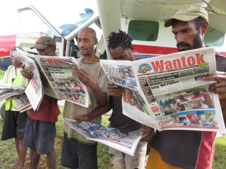 Local men in Hesalibi recreating the original photo displayed on the newspapers they read.
