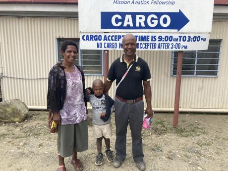 Pastor Tumun Nekints with his wife and last son in front of the cargo base