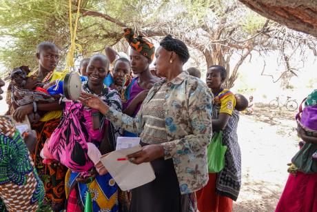 Mama Kambenga, the Kilimatinde Safaris coordinator, conducting child growth monitoring at the mobile clinic held at Mahaka airstrip.