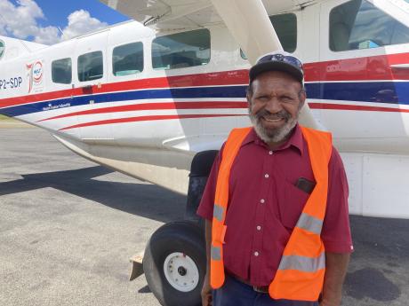 Peter Pyandea standing by an MAF plane
