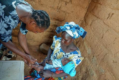 A nurse administering a vaccine to a child at the mobile clinic held at Dabia airstrip.