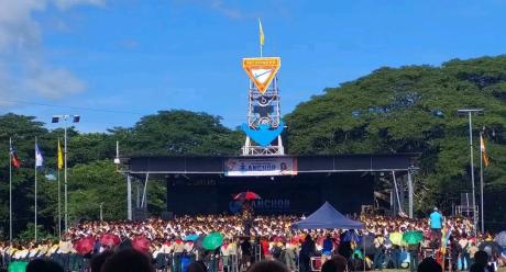 Conference in Lae with a large crowd in front of an outdoor stage.