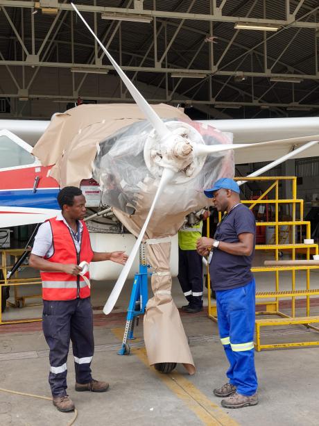 Gift having a conversation with engineer Ian during a propeller paint job at the hangar