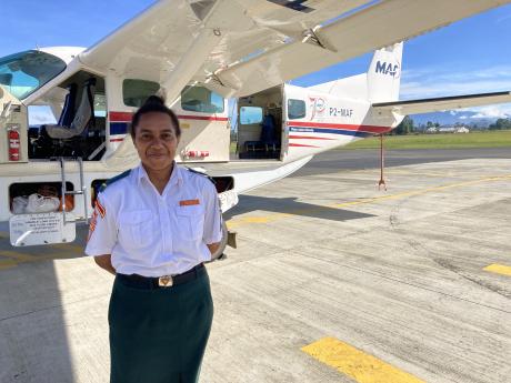 Matilda Sangkol from Balimo Pathfinders standing in front of MAF plane.
