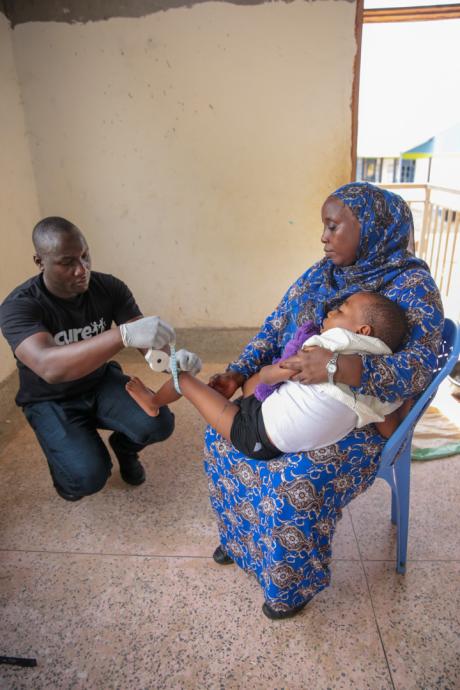 Issa is held by the mother as a technologist takes measurements for an AFO