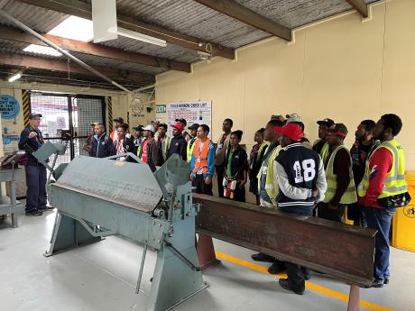 grade 12 students touring MAF's HQ including the sheet metal workshop