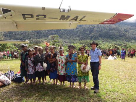 Women at Wobagen travelling to Baptist Conference in Tabubi before boarding the flight stand up for a group photo under the wing of the plane with pilot Bridget