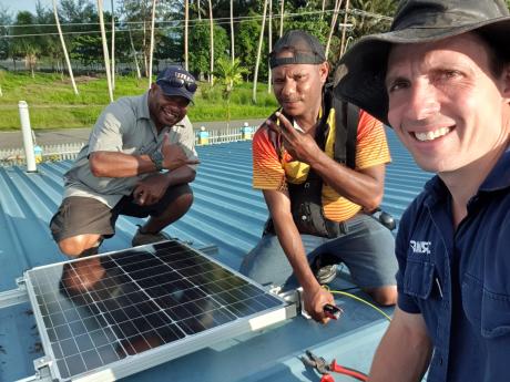 Lukas Shadegg taking a selfie with the team who assisted him install a solar panel for the West Sepik administration.